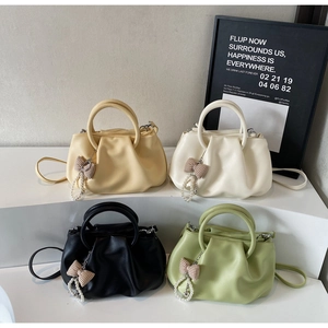 Close-up of cloud pleats and pearl bow charms on trendy handbags in four colors