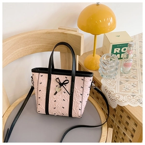 Vue détaillée du sac cabas plissé rose avec nœuds noirs et pendentif en cœur