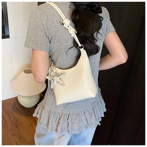 Sac hobo crème chic avec un charme étoile argentée et un détail de nœud à l'épaule
