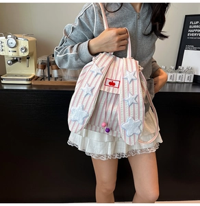 Detail of pink striped backpack with large rabbit ears and star patches on model