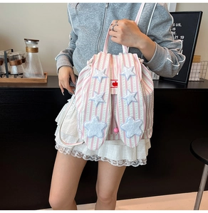 Detail of pink striped canvas backpack with cute plush stars and decorative long rabbit ears