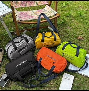 Detailed outdoor view of five colorful durable nylon sports duffle bags with shoulder straps