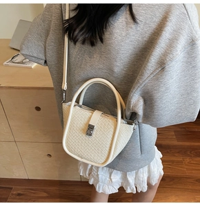 Détail du sac seau blanc cassé avec texture crocodile et boucle métallique argentée