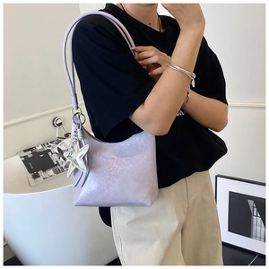 Détail du sac sous l'aisselle violet clair avec texture brillante et pendentif étoile