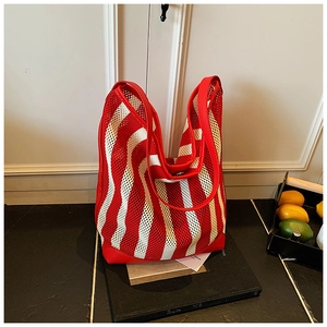 Detail view of red and white striped mesh tote bag with reinforced faux leather handle