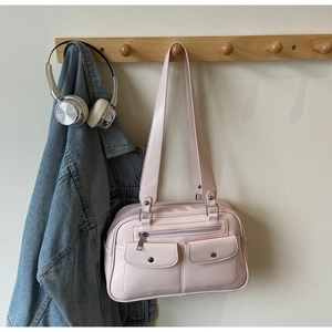 Detail of light pink shoulder bag with double straps, silver hardware, and retro flap pockets