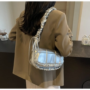 Vue détaillée du sac à bandoulière argenté matelassé avec des détails plissés