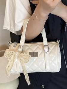 White glossy leather cylinder handbag with quilted pattern and beige lace bow detail