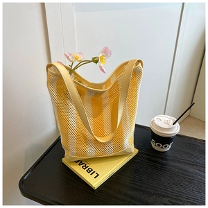 Detail showing yellow and white striped mesh tote bag with durable PU leather handles