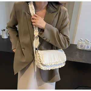 Sac à bandoulière froncé chic avec texture matelassée, porté par un mannequin élégant