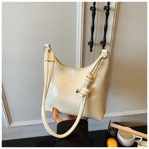 Détail du sac à bandoulière blanc crème avec cuir plissé brillant et bandoulière nouée