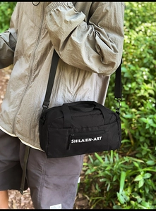Detailed close-up of a black nylon crossbody bag with honeycomb texture and SHILAIEN-ART logo