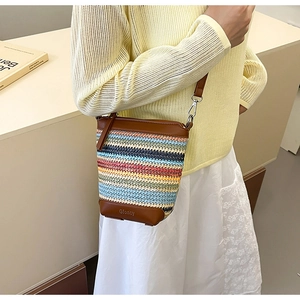 Details der bunten gewebten Beuteltasche mit braunem Lederbesatz und schmalem Schultergurt