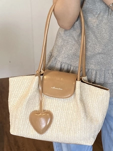 Pastel beige woven tote bag with brown faux leather handles for summer beach vacation