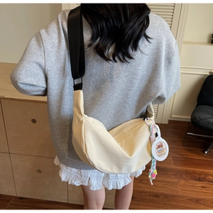 Détail du sac bandoulière croissant crème avec sangle réglable et breloque capybara