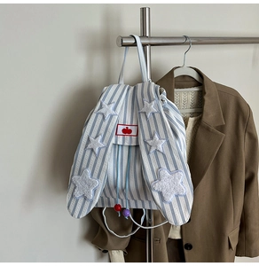 Close-up of blue striped backpack with rabbit ears and plush star details