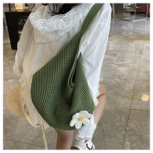 Détail du sac cabas tricoté vert avec marguerite au crochet et texture de tissage serré