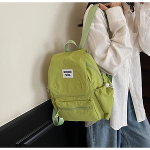 Close-up of lime green nylon backpack with drawstring pockets and adjustable straps