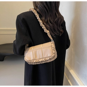 Vue détaillée du sac matelassé abricot avec bandoulière plissée et finition mate élégante