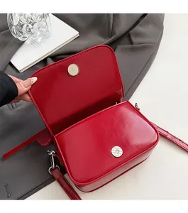 Dettaglio della borsa a tracolla in pelle PU rossa con chiusura magnetica argentata