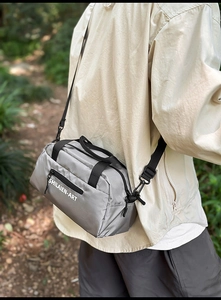 Outdoor model showing gray crossbody sports bag with SHILAIEN-ART logo and nylon strap
