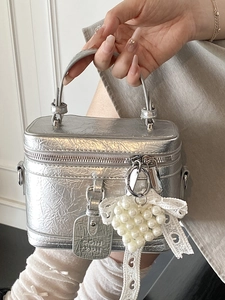 Silver textured handbag with pearl heart pendant and lace bow detail for women