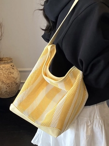 Minimalist yellow striped mesh tote bag with leather trim on model in bright style