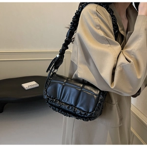 Détail du sac à bandoulière plissé noir avec similicuir matelassé et bandoulière à volants