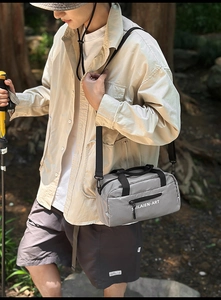 Detail view of light grey nylon messenger bag with white lettering for outdoor use