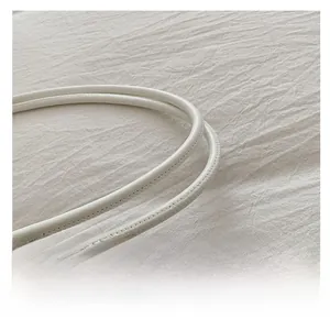 Dettaglio ravvicinato delle cuciture lisce sui manici della borsa tote bianca in ecopelle