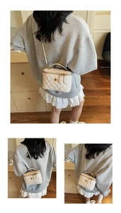 Detail of quilted bucket bag with golden camellia lock and leather chain strap