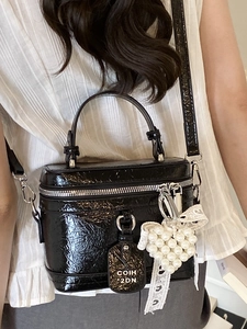 Black patent leather contrast crossbody bag with pearl heart charm and top handle strap