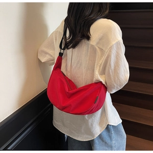 Détail du sac à bandoulière en nylon rouge en forme de demi-lune avec sangle