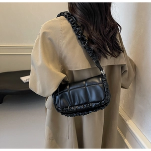 Détail du sac à épaule en cuir synthétique plissé noir avec bandoulière froncée