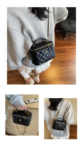 Detailed macro view of black quilted mini vanity bag with gold zipper and chain strap