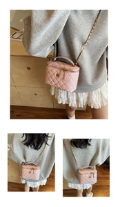 Close-up of pink quilted chain bag with gold floral clasp and leather woven strap