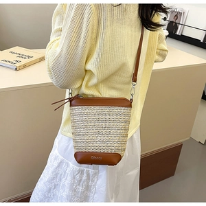 Detail der Stroh-Eimertasche mit Lederboden und verstellbarem Schultergurt an einem Model
