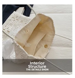 Dettaglio borsa tote in pizzo bianco con fodera in tela e chiusura magnetica dorata lucida