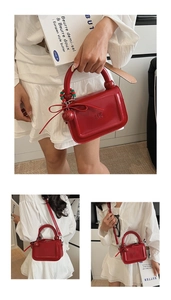 Dettaglio mini borsa rossa lucida con fiocco, ciondolo di perline e tracolla rimovibile