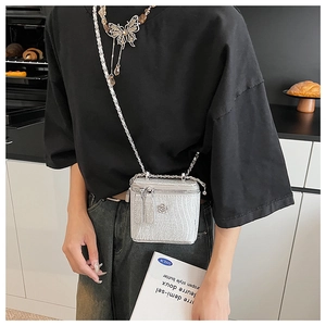 Dettaglio borsa a scatola glitter argento con fiore metallico e tracolla a catena trendy