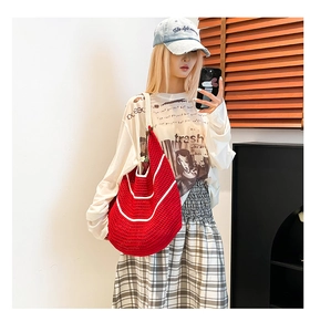 Detailed view of red woven crochet shoulder bag with white stripes and large capacity