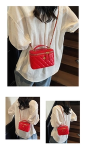 Detail of red quilted bucket bag featuring golden flower ornament and leather chain strap