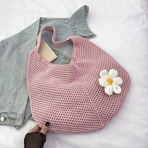 Détail du sac cabas tissé rose avec motif en maille ajourée et détail de fleur de marguerite