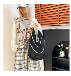Detailed view of handmade black and white crochet tote bag with wave pattern stitching