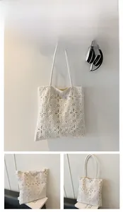 Dettaglio della borsa tote in pizzo bianco traforato con motivi floreali e manici