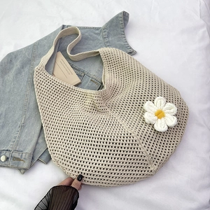 Détail d'une fleur 3D tricotée à la main sur un sac de plage d'été en maille ajourée