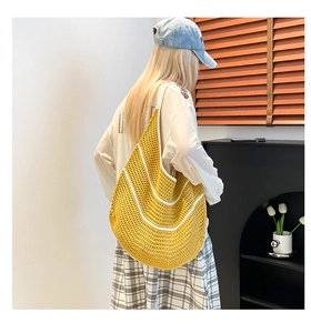 Model view of yellow knit tote with white stripes and spacious crescent design
