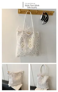 Dettaglio borsa tote in pizzo bianco con motivi floreali e fiocco di fragola rosa