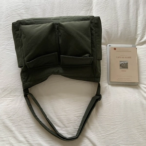 Detail view of olive green canvas messenger bag with double pockets and adjustable strap