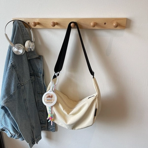 Sac bandoulière demi-lune beige chic avec bandoulière large et breloque capybara